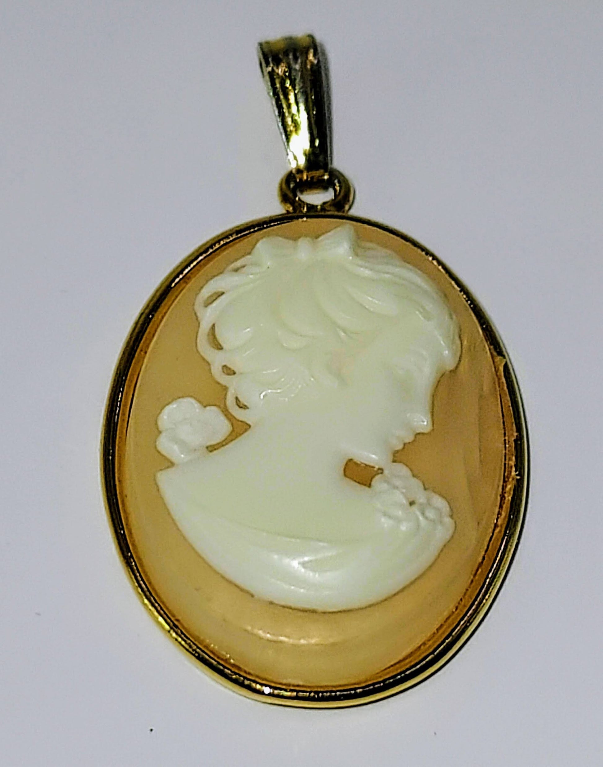 Oval Shell Cameo set in gold bezel.  Young female profile w/blossoms