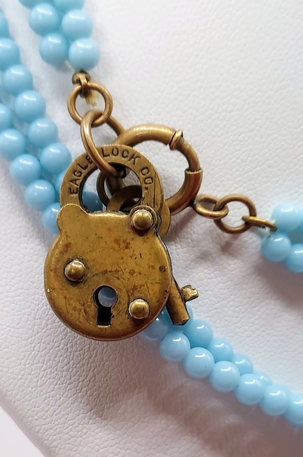 Angel Skin Coral 30-Inch Blue Bead Necklace, on cord with brass lock novelty clasp and pink carved coral bunny charm